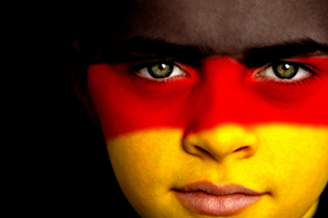 Portrait of a young German football / soccer fan, with the German Flag on his face.