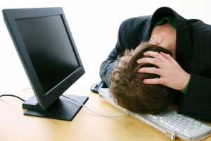 Femme désespérée au travail, allongée sur son clavier, se prend la tête