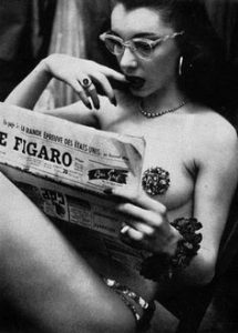 Une artiste de burlesque lit le journal avant de monter sur scène